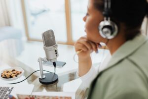 pexels photo 5399014 5399014 Woman using laptop and microphone for podcasting at home.